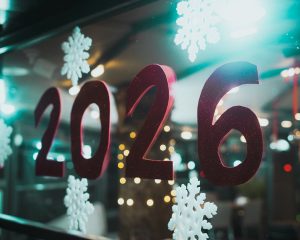 Foto von Christian Agbede auf Unsplash. (Für Alt-Text: Red 2026 numbers with snowflakes on window)